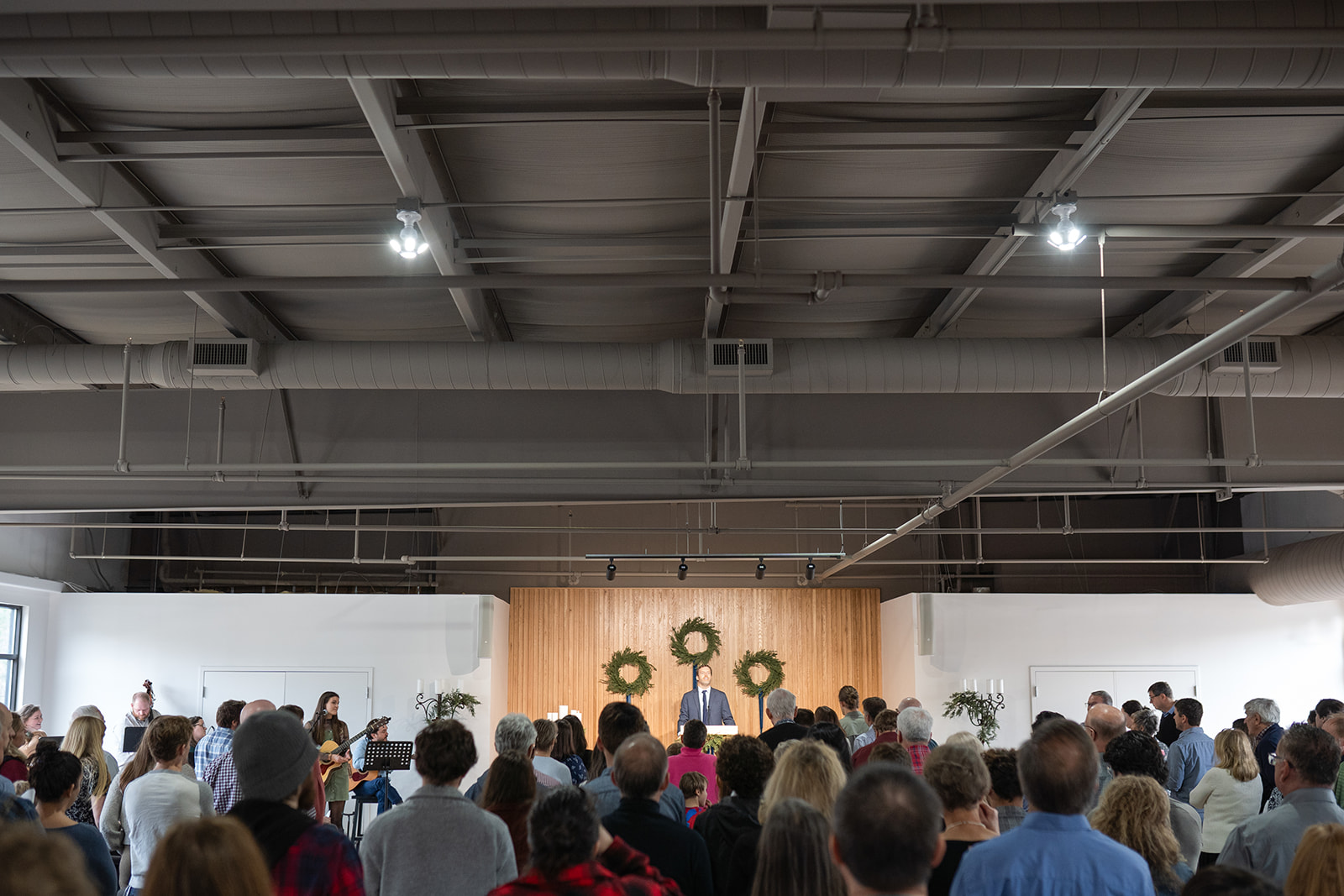 Church congregation standing to look at pastor